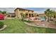 This backyard features a large pool, fire pit, and lush landscaping with comfortable seating at 11150 S Star Ct, Goodyear, AZ 85338