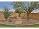 The backyard has stone landscaping with desert plants and built in stone benches at 11150 S Star Ct, Goodyear, AZ 85338