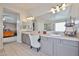 Bright bathroom with dual sinks, large mirror, and vanity with chair at 11150 S Star Ct, Goodyear, AZ 85338