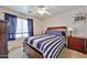 Well-lit bedroom featuring a ceiling fan, a window with blinds and a bed with side tables at 11150 S Star Ct, Goodyear, AZ 85338