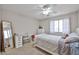 This bedroom features carpet, neutral walls, white furniture, natural light, and a ceiling fan at 11150 S Star Ct, Goodyear, AZ 85338
