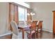 Elegant dining room with a wooden table, chandelier, and large window for natural light at 11150 S Star Ct, Goodyear, AZ 85338