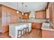 This kitchen has granite counters, stainless appliances, wooden cabinets, and a center island with seating at 11150 S Star Ct, Goodyear, AZ 85338
