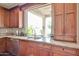 The kitchen sink has granite counters, wooden cabinets, stainless appliances and a view of the backyard at 11150 S Star Ct, Goodyear, AZ 85338