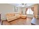 Bright living room with hardwood floors, featuring a sectional sofa and cozy window lighting at 11150 S Star Ct, Goodyear, AZ 85338