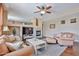 Inviting living room featuring a stone fireplace, plush seating, and a ceiling fan for comfort at 11150 S Star Ct, Goodyear, AZ 85338
