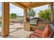 Covered patio featuring a built-in grill area with a stainless steel grill, tiled backsplash, and seating at 11150 S Star Ct, Goodyear, AZ 85338