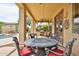 Covered patio featuring an outdoor dining area, a built-in grill, and views of the backyard pool and landscaping at 11150 S Star Ct, Goodyear, AZ 85338