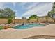 Beautiful backyard pool with a rock waterfall feature, surrounded by lush landscaping and a spacious patio area at 11150 S Star Ct, Goodyear, AZ 85338