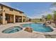 Inviting backyard featuring a pool, spa, rock waterfall, and lush landscaping, creating a private oasis at 11150 S Star Ct, Goodyear, AZ 85338