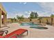 Backyard pool and spa with a rock waterfall, spacious patio, lush landscaping, and comfortable lounge seating at 11150 S Star Ct, Goodyear, AZ 85338