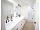 Bright bathroom boasts dual sinks, white cabinetry, and a sleek glass-enclosed shower at 1142 E Westchester Dr, Tempe, AZ 85283