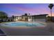 Beautiful backyard featuring an in-ground pool with ample space for entertaining under the covered patio at twilight at 1209 E Marigold Ln, Tempe, AZ 85288