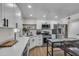 Bright kitchen features white cabinets, stainless appliances, quartz counters, and wood look tile flooring at 1209 E Marigold Ln, Tempe, AZ 85288