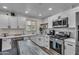Bright kitchen featuring quartz countertops, stainless steel appliances, white cabinets, and light fixtures at 1209 E Marigold Ln, Tempe, AZ 85288