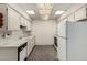 Compact kitchen featuring white cabinets, tile floors and an included refrigerator at 13428 N 100Th Ave, Sun City, AZ 85351