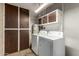 Functional laundry room with washer, dryer, and water heater, adjacent to built-in shelving at 13428 N 100Th Ave, Sun City, AZ 85351