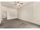 Neutral toned living room featuring neutral carpet, a ceiling fan and white walls at 13428 N 100Th Ave, Sun City, AZ 85351