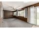 Spacious living room featuring paneled walls, neutral carpet, and a sliding glass door at 13428 N 100Th Ave, Sun City, AZ 85351