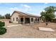 Gravel backyard featuring a covered patio, solar panels, and a privacy fence at 13438 N 130Th Ln, El Mirage, AZ 85335
