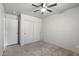 Bedroom with ceiling fan, closet with sliding doors, and white trim at 13438 N 130Th Ln, El Mirage, AZ 85335