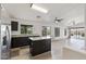 Open concept kitchen with stainless steel refrigerator and island overlooking the great room at 13438 N 130Th Ln, El Mirage, AZ 85335