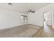 Spacious living room with neutral carpet, a ceiling fan, and a large window at 13438 N 130Th Ln, El Mirage, AZ 85335