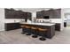 Gourmet kitchen featuring dark wood cabinetry, a center island with seating, and modern appliances at 14837 W Honeysuckle Dr, Surprise, AZ 85387