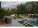 Outdoor kitchen and entertainment area featuring a built-in grill, bar seating, pool and hot tub at 1529 W State Ave, Phoenix, AZ 85021