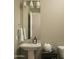 Cozy, modern powder room with elegant pedestal sink, designer mirror, and muted neutral palette at 1529 W State Ave, Phoenix, AZ 85021