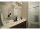 Traditional bathroom with a double sink vanity and a view to the glass-enclosed tiled shower at 1529 W State Ave, Phoenix, AZ 85021