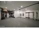 Spacious garage with epoxy flooring, storage racks, an electric vehicle charger, and overhead lighting at 1529 W State Ave, Phoenix, AZ 85021
