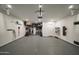 Spacious garage with epoxy flooring, storage racks, an electric vehicle charger, and overhead lighting at 1529 W State Ave, Phoenix, AZ 85021
