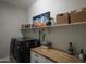 Functional laundry room with modern appliances, built-in shelving, and ample counter space at 1529 W State Ave, Phoenix, AZ 85021