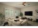 Cozy living room featuring a comfortable sectional sofa, a ceiling fan, and bright, shuttered windows at 1529 W State Ave, Phoenix, AZ 85021