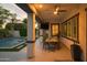 Inviting covered patio with a ceiling fan, outdoor TV, a dining table, and access to the backyard pool at 1529 W State Ave, Phoenix, AZ 85021