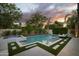 Luxury outdoor pool and spa area with modern tiling, lush landscaping, and lounge seating at 1529 W State Ave, Phoenix, AZ 85021