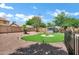 Gravel backyard featuring a manicured lawn, privacy fence, and a covered hot tub at 1565 E Prickly Pear Pl, Casa Grande, AZ 85122
