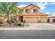 Charming two-story home featuring a tile roof, three-car garage, and low maintenance desert landscaping at 1565 E Prickly Pear Pl, Casa Grande, AZ 85122