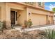 A welcoming front porch featuring stone accents, a rustic wood door, and a three-car garage at 1565 E Prickly Pear Pl, Casa Grande, AZ 85122