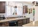 The kitchen boasts dark wood cabinets, granite countertops, stainless steel appliances, and a view to the backyard at 1565 E Prickly Pear Pl, Casa Grande, AZ 85122