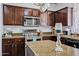 The kitchen features dark wood cabinets, granite countertops, stainless steel appliances, and a kitchen island at 1565 E Prickly Pear Pl, Casa Grande, AZ 85122