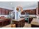 A beautiful kitchen features granite countertops, dark wood cabinets, stainless steel appliances, and tile flooring at 1565 E Prickly Pear Pl, Casa Grande, AZ 85122