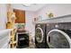 Well-equipped laundry room with modern washer and dryer, storage shelves and pet supplies at 1565 E Prickly Pear Pl, Casa Grande, AZ 85122