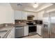 The kitchen has stainless steel appliances, white cabinets, and tile backsplash at 1645 W Baseline Rd # 2098, Mesa, AZ 85202