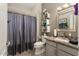 Well-lit bathroom featuring tiled floors, granite counters, a modern vanity, decorative shelving, and a shower with a curtain at 16514 W Sandia Park Dr, Surprise, AZ 85374