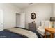 Comfortable bedroom featuring tiled floors, neutral decor, a side table with a lamp, and an accent chair at 16514 W Sandia Park Dr, Surprise, AZ 85374