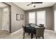 Cozy dining area with tiled floor, two windows, gray walls, and a round table, illuminated by a ceiling fan with light fixture at 16514 W Sandia Park Dr, Surprise, AZ 85374