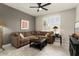 Comfortable living room with ceiling fan, plush couch, and bright window at 16514 W Sandia Park Dr, Surprise, AZ 85374