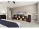 This large bedroom offers tiled floors, neutral paint, and decorative shelving with a TV and sitting area at 16514 W Sandia Park Dr, Surprise, AZ 85374